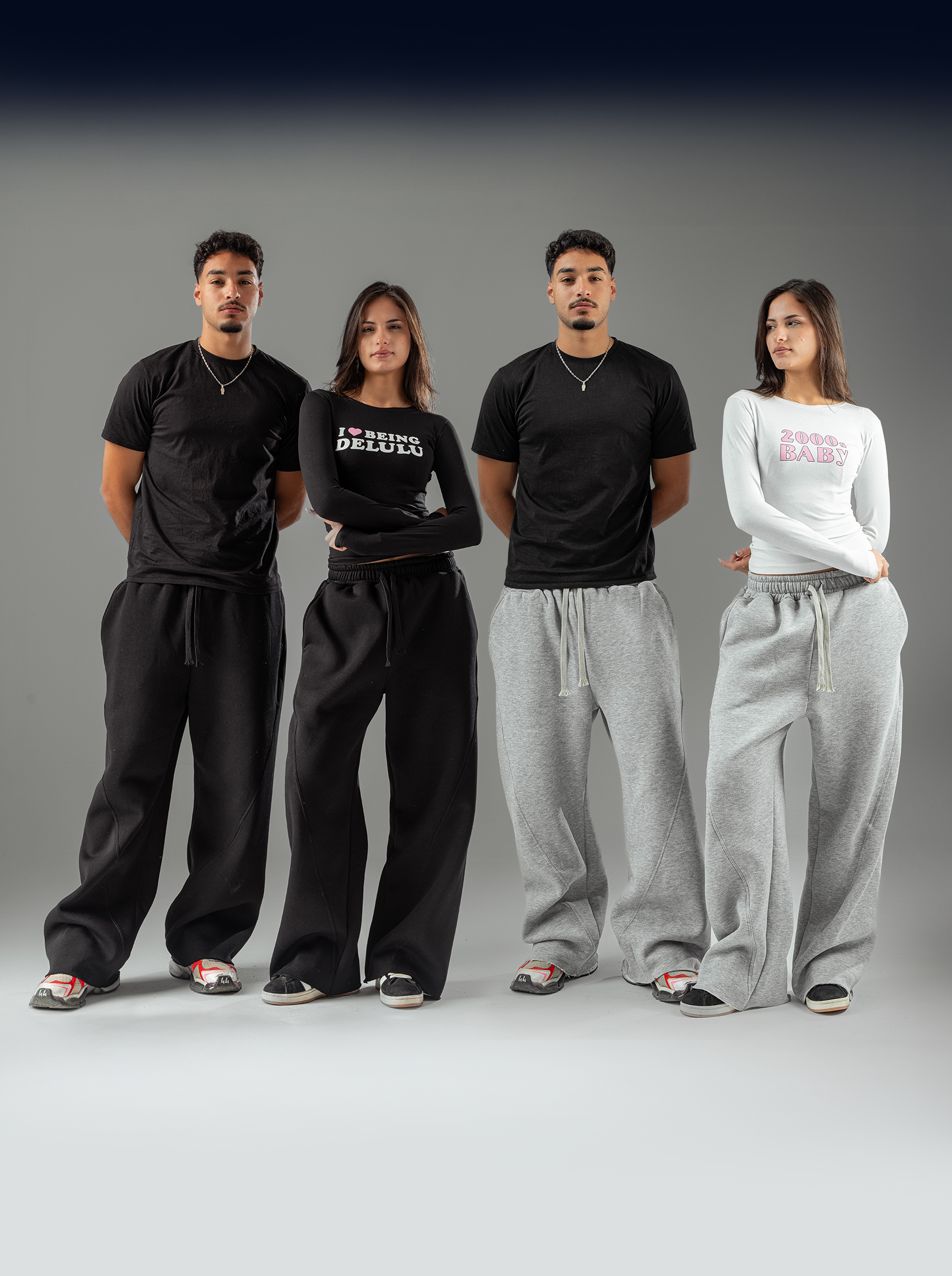 Four individuals wearing black and gray sweatpants on a gray background
